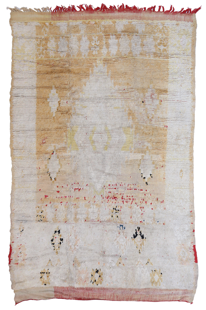 Tapis berbère aux motifs géométriques, dominé par des teintes beige, crème et touches de rouge.