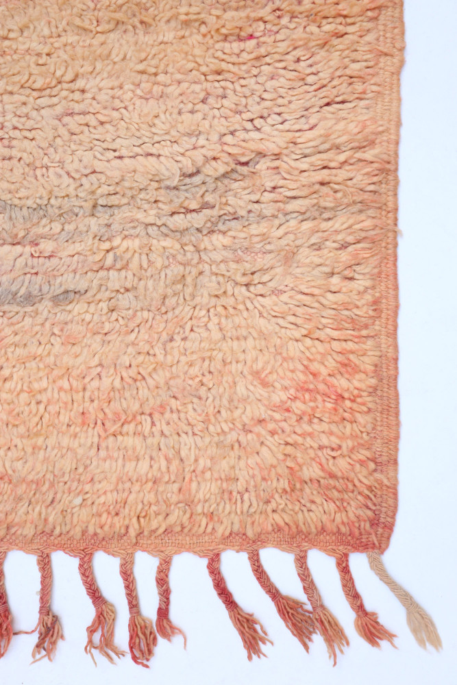 Tapis berbère aux teintes douces, orangées et motifs texturés, apportant chaleur et authenticité à votre intérieur.