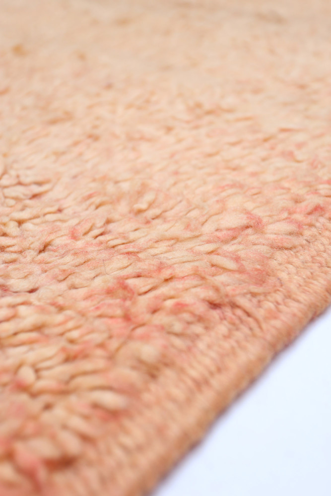 Tapis berbère à texture douce, dans des teintes de rose et beige avec un motif subtil et naturel.
