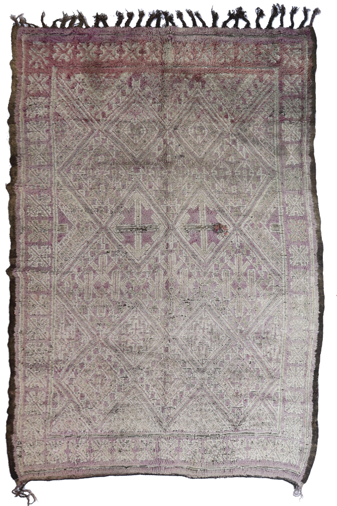 Tapis berbère aux motifs géométriques en tons de beige et rose, créant une ambiance chaleureuse et rustique.