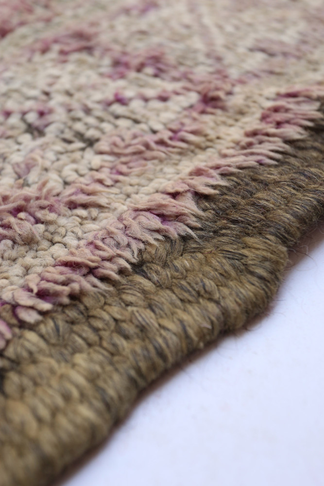 Tapis berbère à motifs géométriques, aux nuances de beige et rose, ajoutant une touche chaleureuse à votre intérieur.