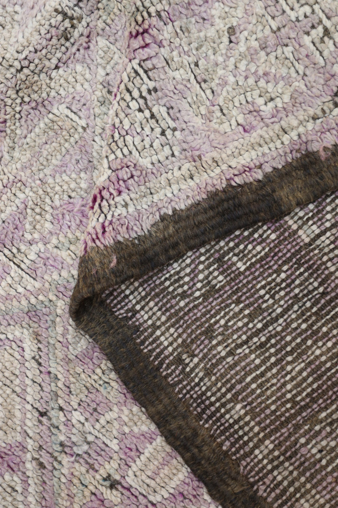Tapis berbère aux motifs géométriques, dominante de rose et marron, apportant un style contemporain et chaleureux.