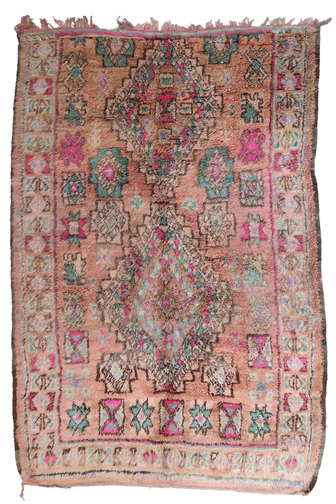 Tapis berbère aux motifs géométriques colorés, dominé par des teintes roses et vertes sur un fond chaud.