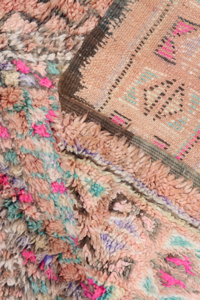 Tapis berbère aux tons pastel, motifs géométriques colorés et textures douces apportant une ambiance chaleureuse.