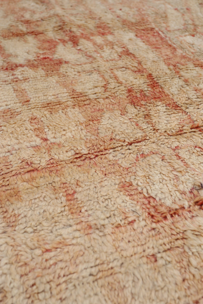 Tapis berbère en beige avec des motifs géométriques et des touches de rouge, apportant chaleur et authenticité à votre décor.