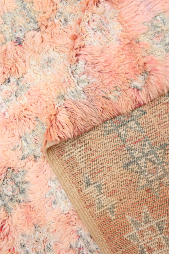 Tapis berbère aux tons rose et beige avec des motifs étoilés et une texture douce, idéal pour une décoration chaleureuse.