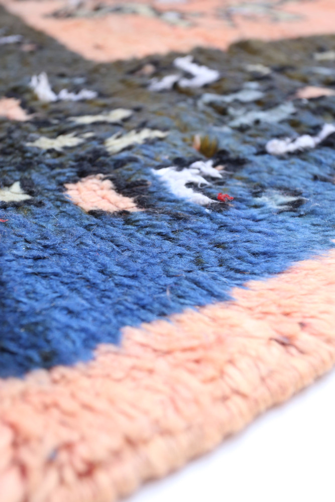 Tapis berbère en laine aux couleurs bleu, rose et motifs géométriques modernes, ajoutant une touche d\'élégance à tout intérieur
