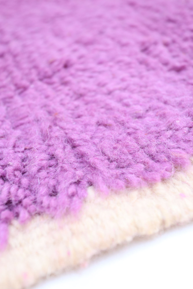Tapis berbère en laine avec des teintes de violet et un motif texturé, idéal pour un intérieur moderne.