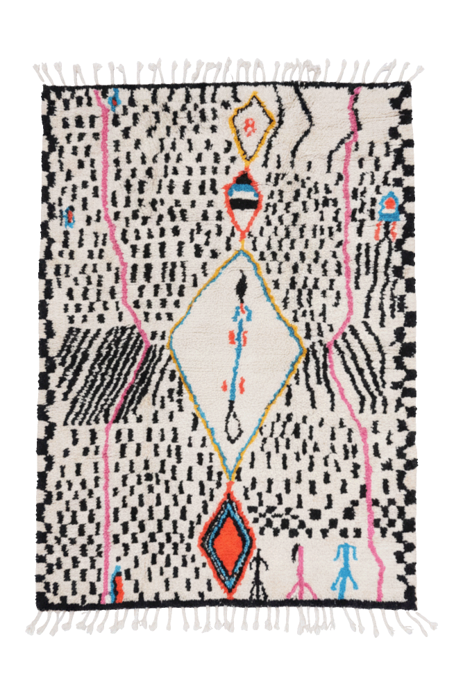 Tapis berbère aux motifs géométriques colorés, avec des nuances de noir, blanc, rouge et rose, idéal pour un intérieur moderne.