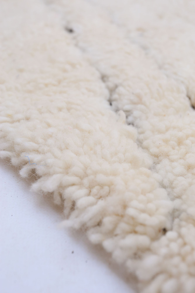 Tapis berbère texturé en laine blanche avec des motifs naturel et moderne, parfait pour une décoration chaleureuse.