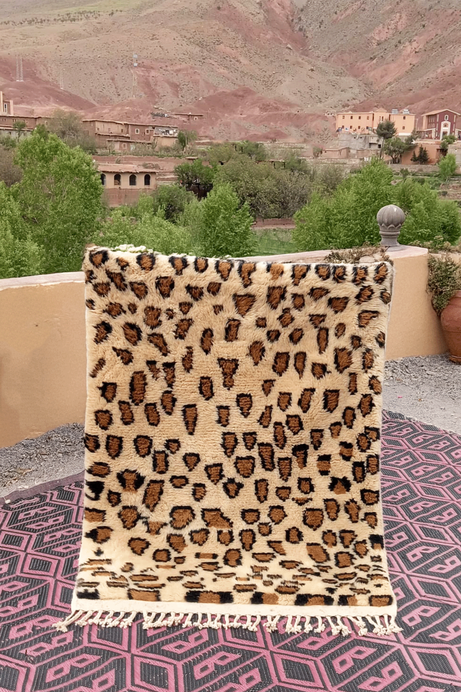 Tapis berbère aux motifs de léopard en tons crème et marron, parfait pour un style décoratif contemporain.