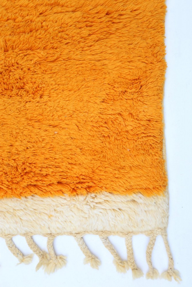 Tapis berbère en laine douce, couleur orange éclatant avec une bordure crème et finitions à franges.