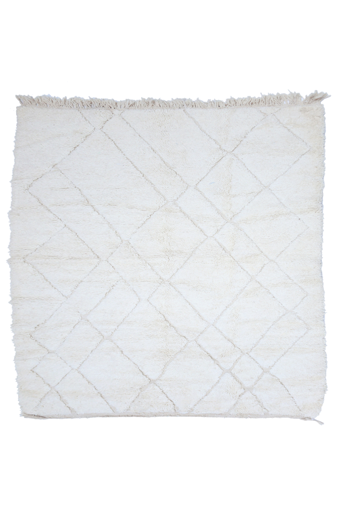 Tapis berbère en laine, de style minimaliste, avec des motifs géométriques en blanc et crème.