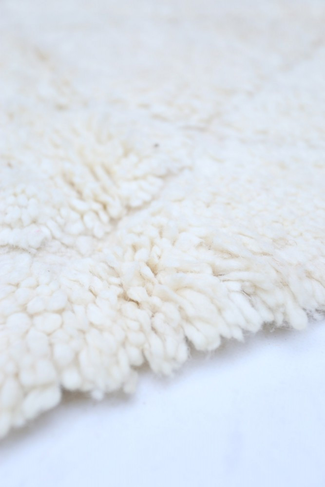Tapis berbère en laine blanche, à texture douce avec motif minimaliste et élégant, parfait pour un intérieur moderne.