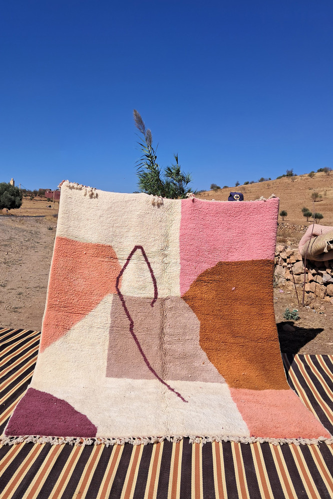 Tapis berbère aux formes géométriques, couleurs pastel dominantes et motifs modernes.