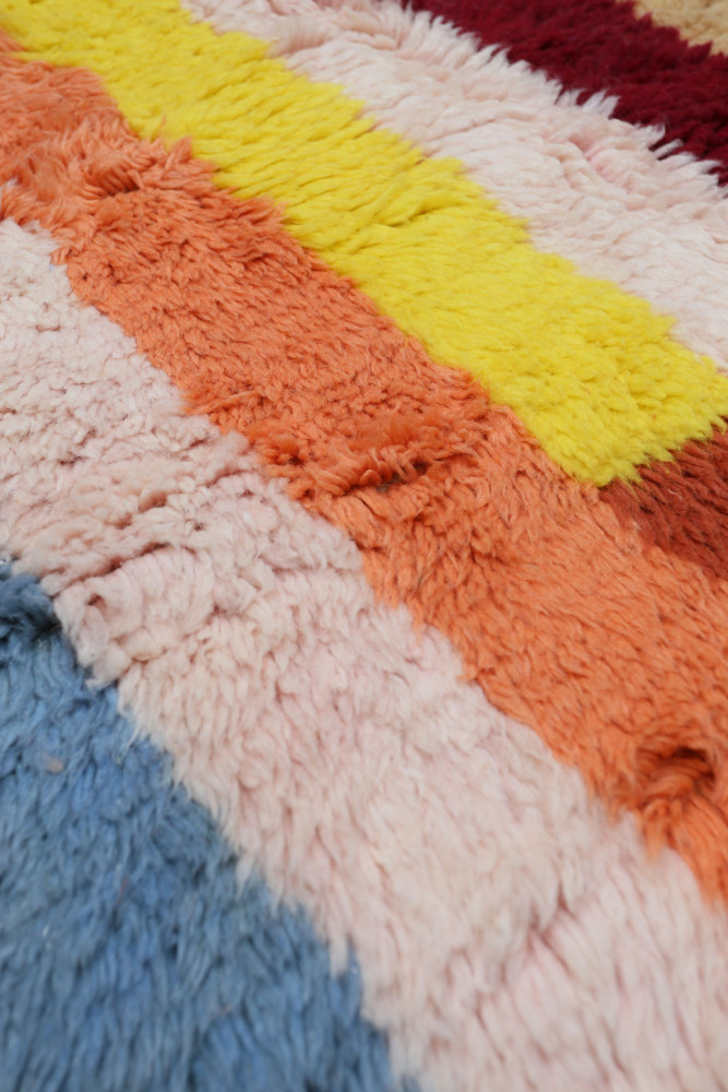 Tapis berbère coloré avec des rayures de peaux douces dans des teintes vives.