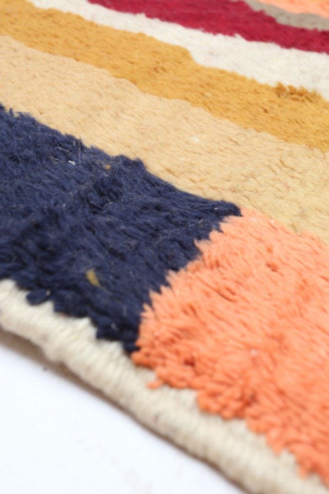 Tapis berbère aux couleurs vives avec des motifs géométriques en laine.